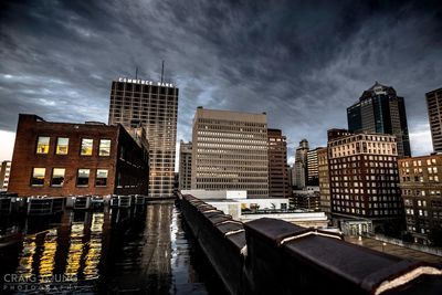 City at waterfront against cloudy sky