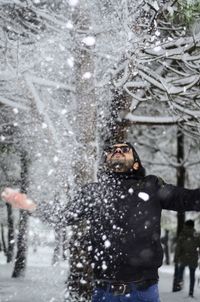 Reflection of man in snow covered tree