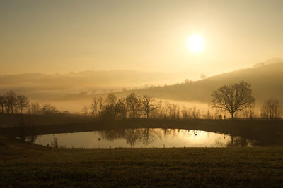 Scenic view of lake against sky during sunrise