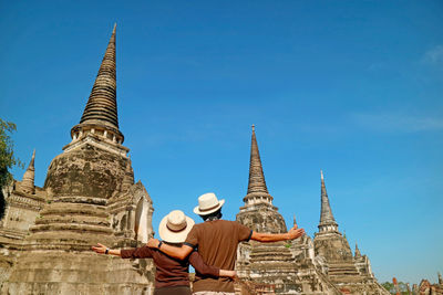 Couple being impressed by the fantastic pagoda ruins of wat phra si sanphet, ayutthaya, thailand