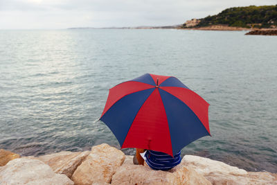 Red umbrella on rock at beach