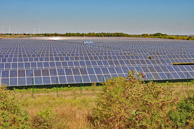 Solar panels in field against sky