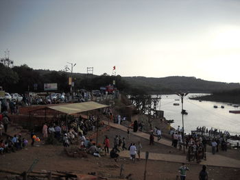 People on beach against sky in city