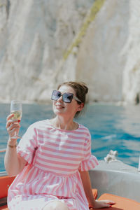 Portrait of a young girl drinking champagne in a boat.