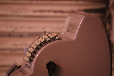 Close-up of vintage cash register against wall