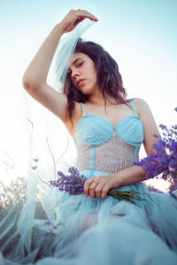 A beautiful young girl against the sunset and a beautiful sky in a lavender field. 