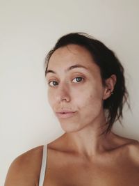 Portrait of young woman against white background