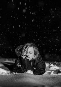 Portrait of kid lying on snow at night