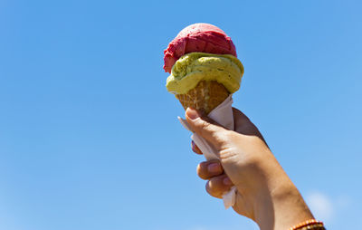 Gelati ice cream cone held up to the hot summer sky