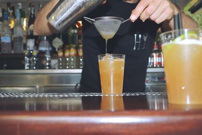 Midsection of man pouring wine in glass