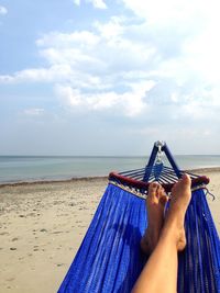 Low section of woman relaxing on beach