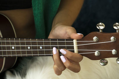 Midsection of woman playing guitar