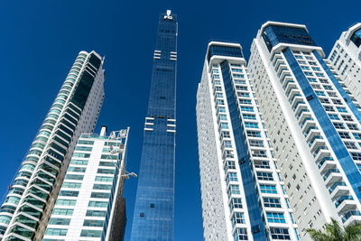 Low angle view of modern buildings against clear blue sky