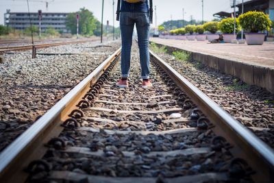 Low section of person standing on railroad track