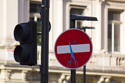 Stop road sign with scissors drawn on it, street art in the center of london