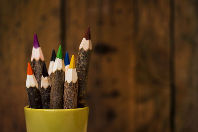 Close-up of multi colored pencils in pen holder on table