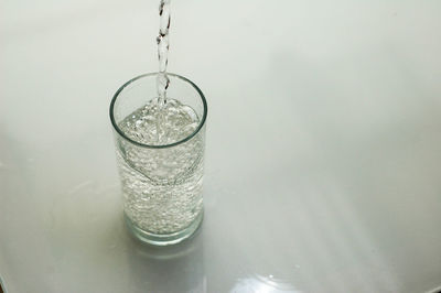 High angle view of drink pouring in drinking glass