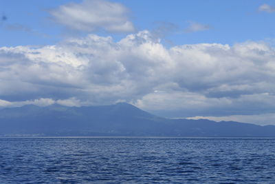 Scenic view of sea and mountains against sky