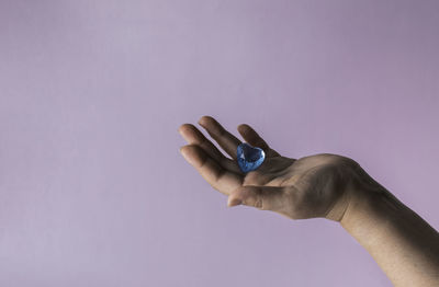 Blue glass heart in woman hand. love concept on valentine day.