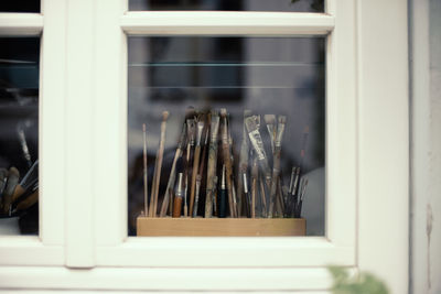 Close-up of artist brushes behind glass window