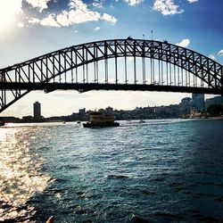 Bridge over river against cloudy sky