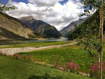 Scenic view of green landscape and mountains against sky
