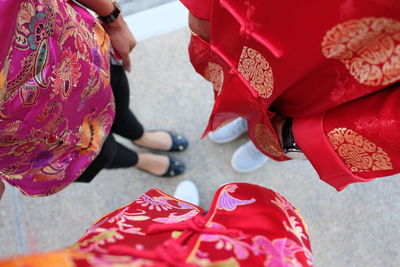 Low section of woman holding red umbrella