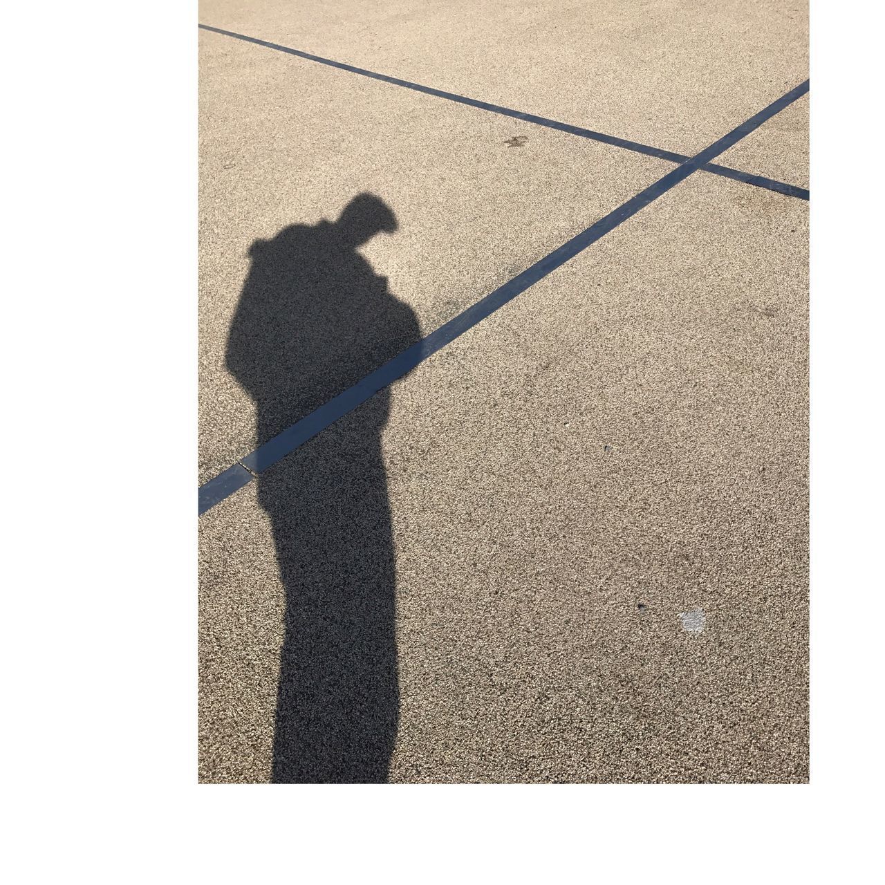 SHADOW OF PERSON ON STREET IN CITY