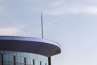 Low angle view of airplane flying against cloudy sky