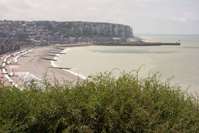 Scenic view of sea by city against sky