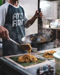 Midsection of man preparing food in kitchen