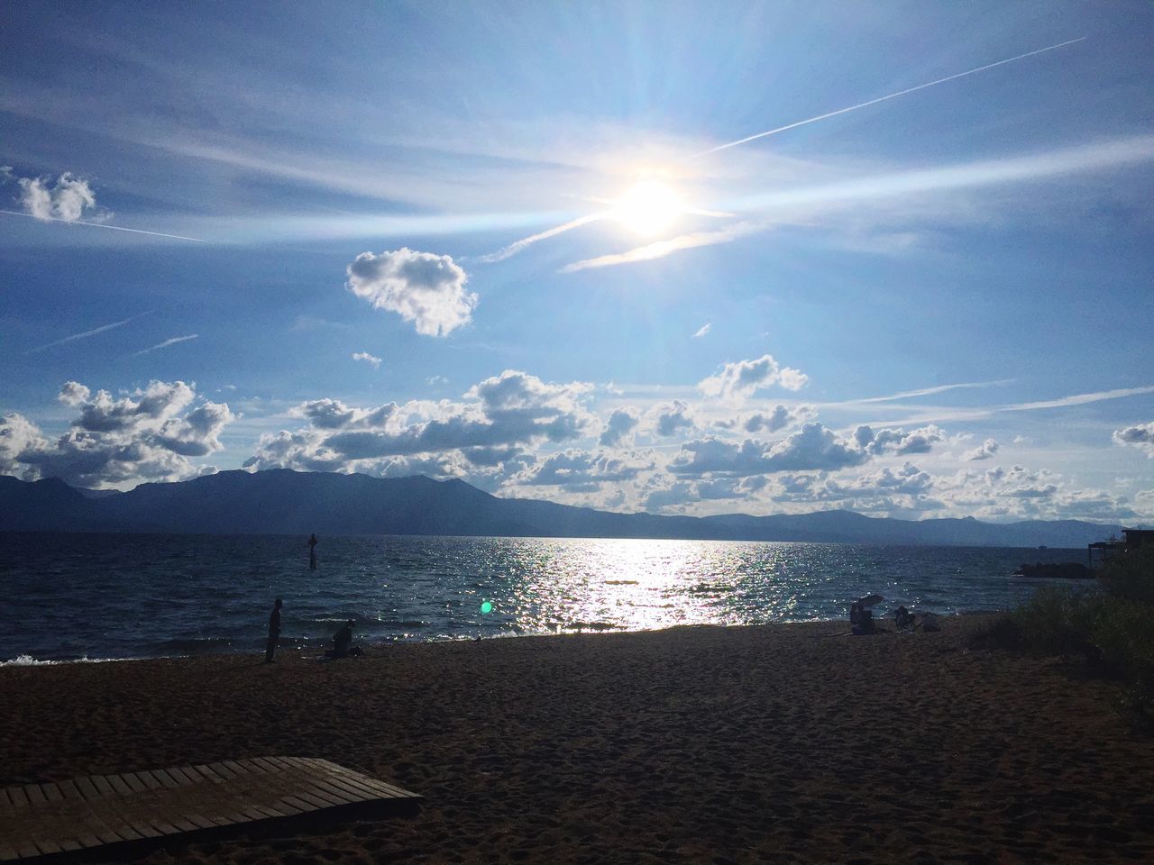 water, sun, tranquil scene, sky, scenics, tranquility, sunlight, sea, beauty in nature, mountain, sunbeam, nature, mountain range, sunny, lens flare, beach, idyllic, cloud - sky, blue, cloud