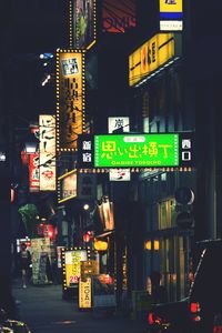 Illuminated sign on street in city at night