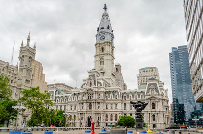 Buildings in city against cloudy sky