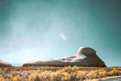 Rock on field against sky