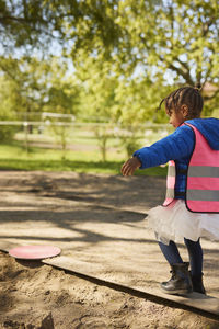 Girl wearing pink vest in park
