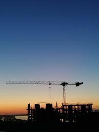 Crane against clear sky during sunset