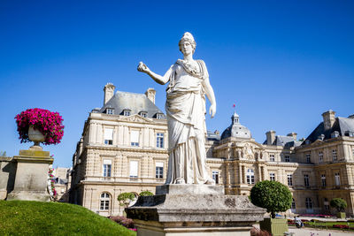 Low angle view of statue against buildings