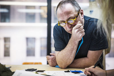 Man holding paper while sitting on table