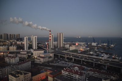 Smoke emitting from factory against clear sky