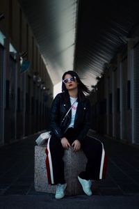 Full length of young woman sitting in sunglasses