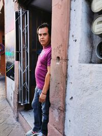 Portrait of boy standing by door of building