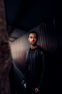 Portrait of young man standing in corridor