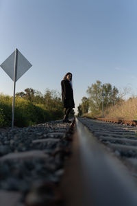 Man standing on railroad track against clear sky