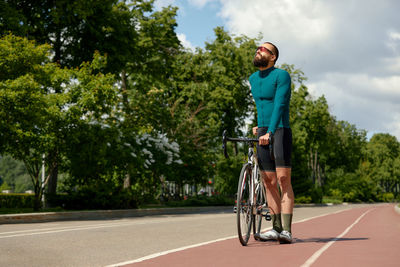 Rear view of man riding bicycle on road