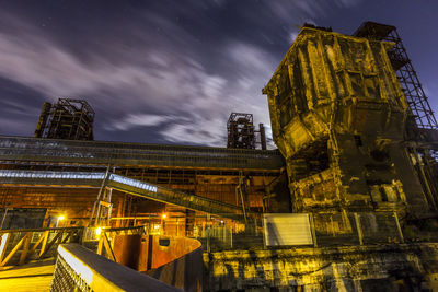 Low angle view of illuminated cityscape against sky at night