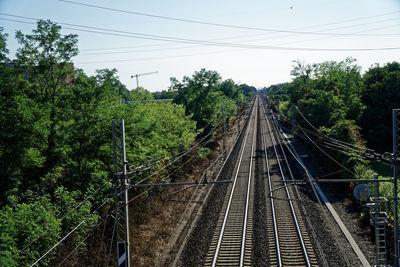 Railroad tracks by trees against sky