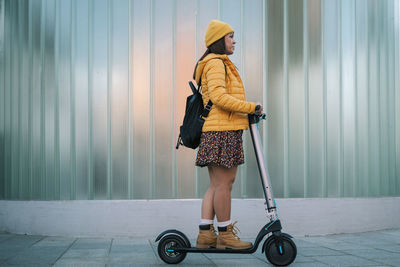 Full length rear view of woman walking on footpath