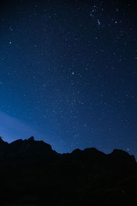 Low angle view of silhouette mountain against sky at night