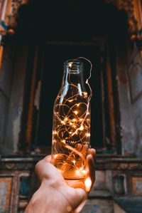 Person holding illuminated candle